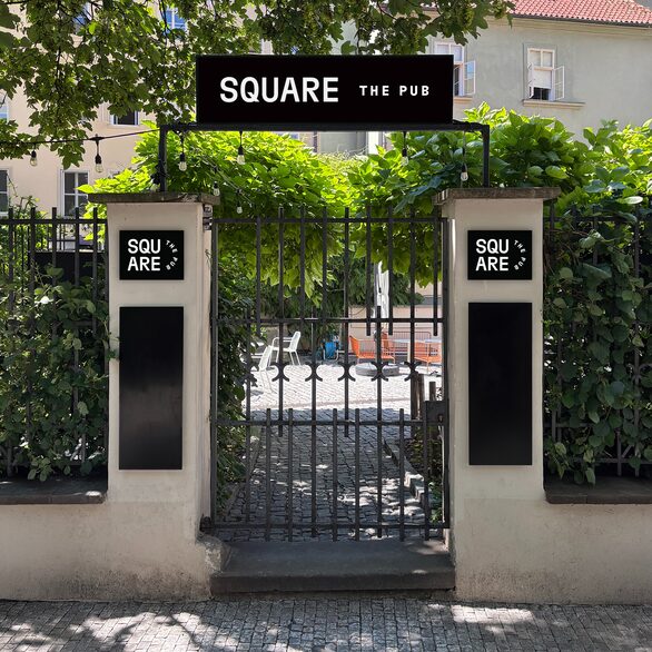 Vstup do Square the Pub, kovaná brána se značkou nad vchodem